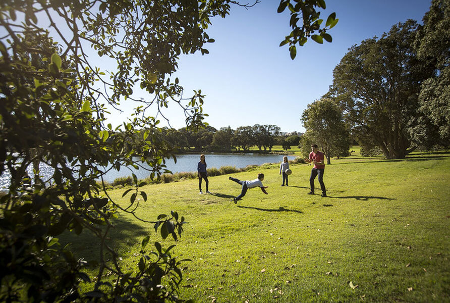 Family playing soccer in park