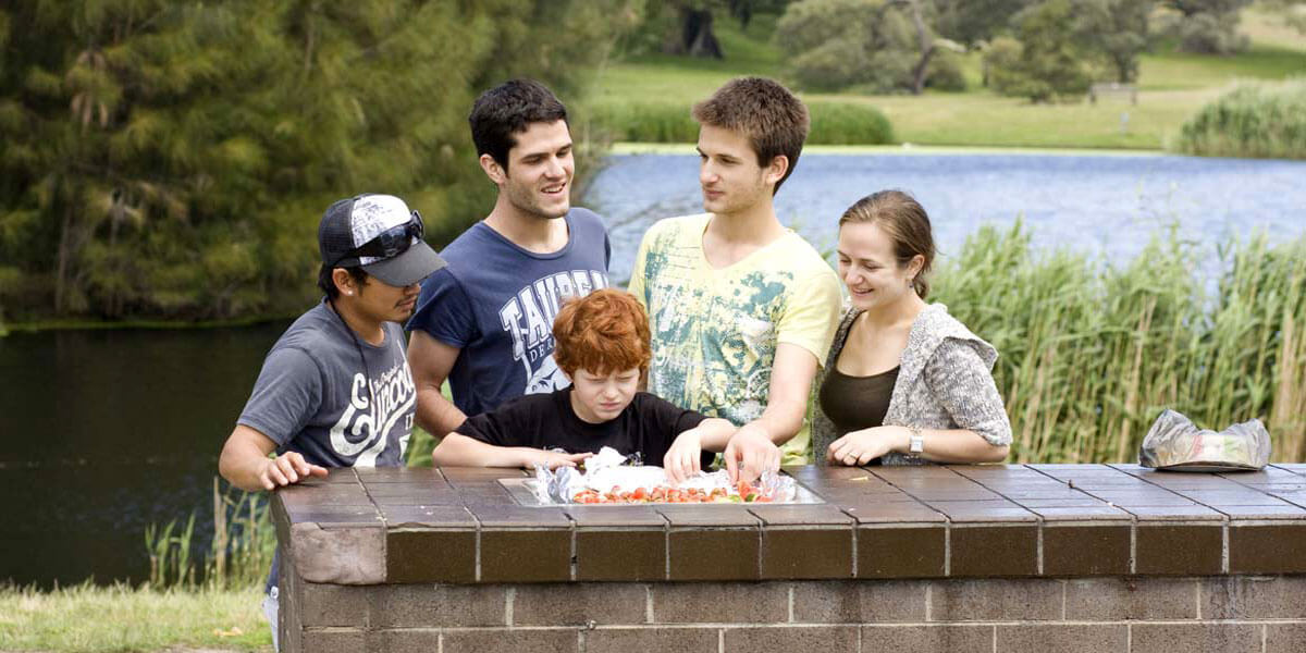 Teenagers making lunch in park