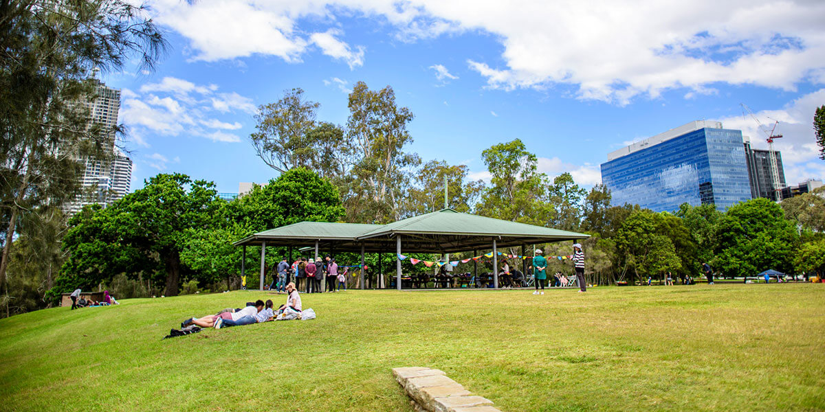 People under shade shelter in park