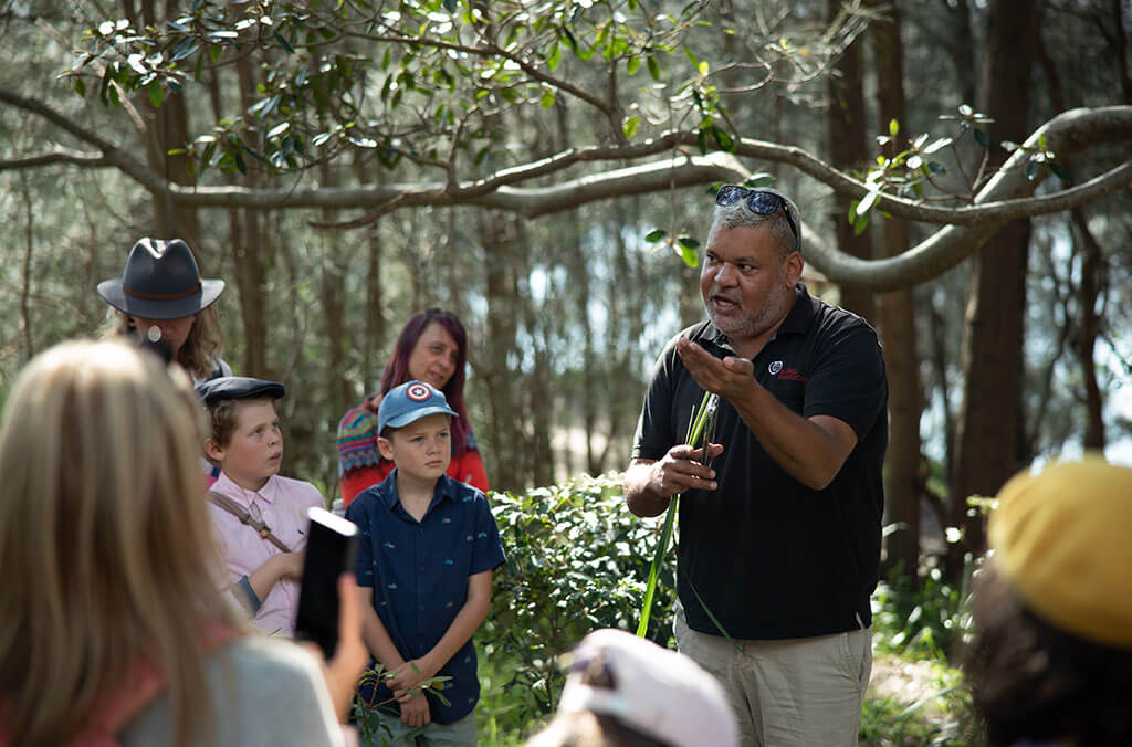Indigenous park ranger giving lesson in bush