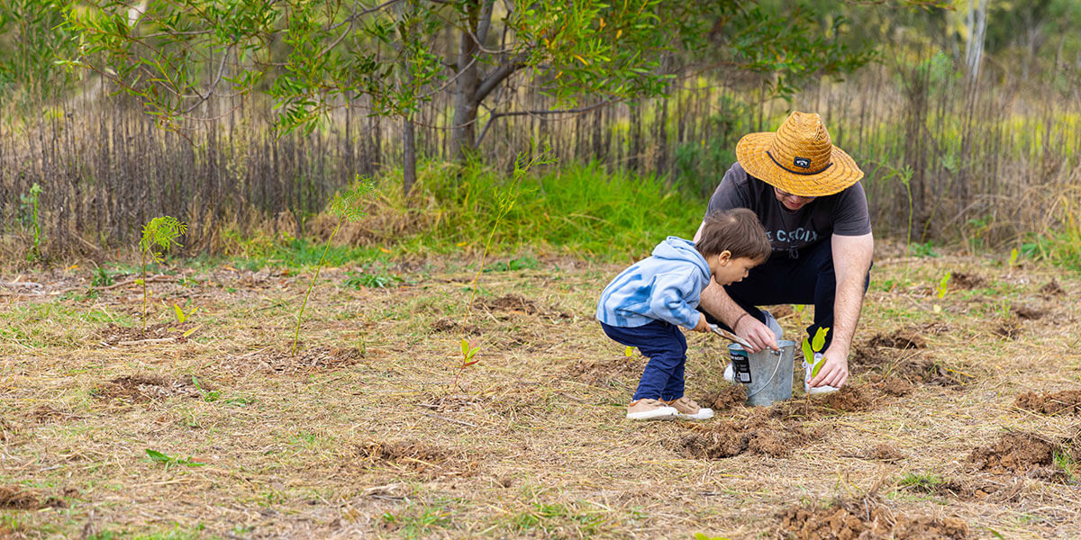 Woman and child planting tree in park