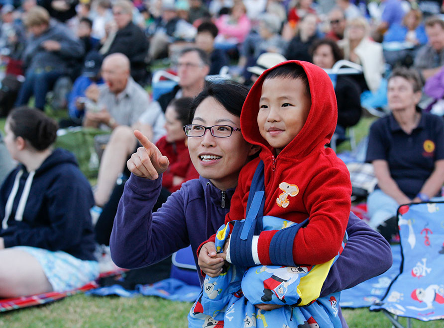 Woman and child watching concert in park