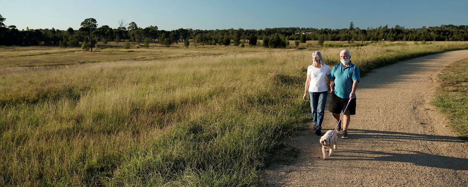 A man and woman walk their dog along the Heart Crossing Loop.