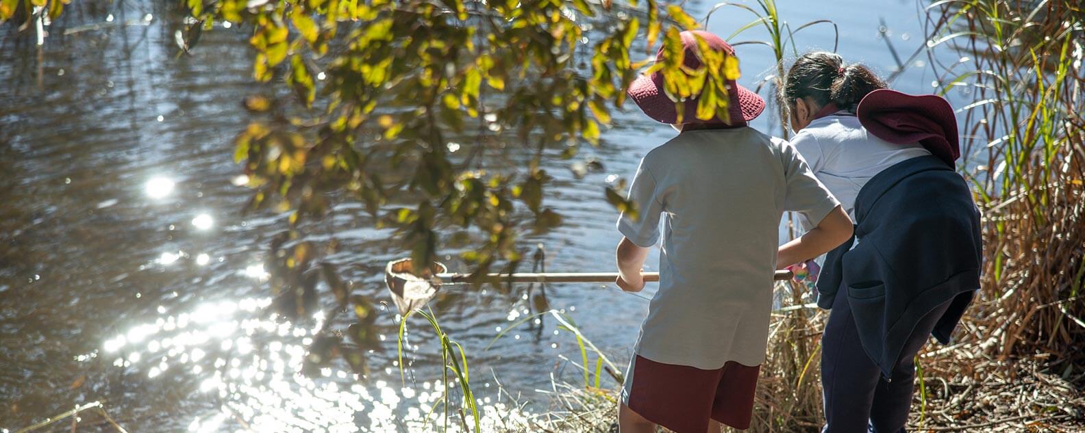 Two kids fishing at a pond on the Lizard Log Kids Trail.