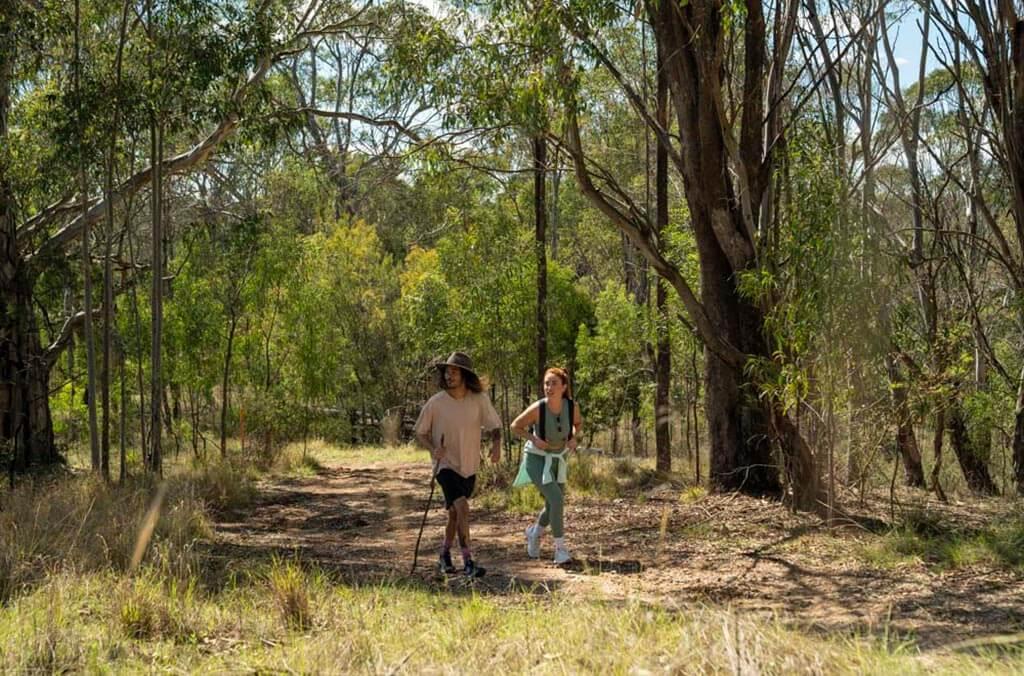 A pair of hikers walk together on the Spotted Gums Trail.