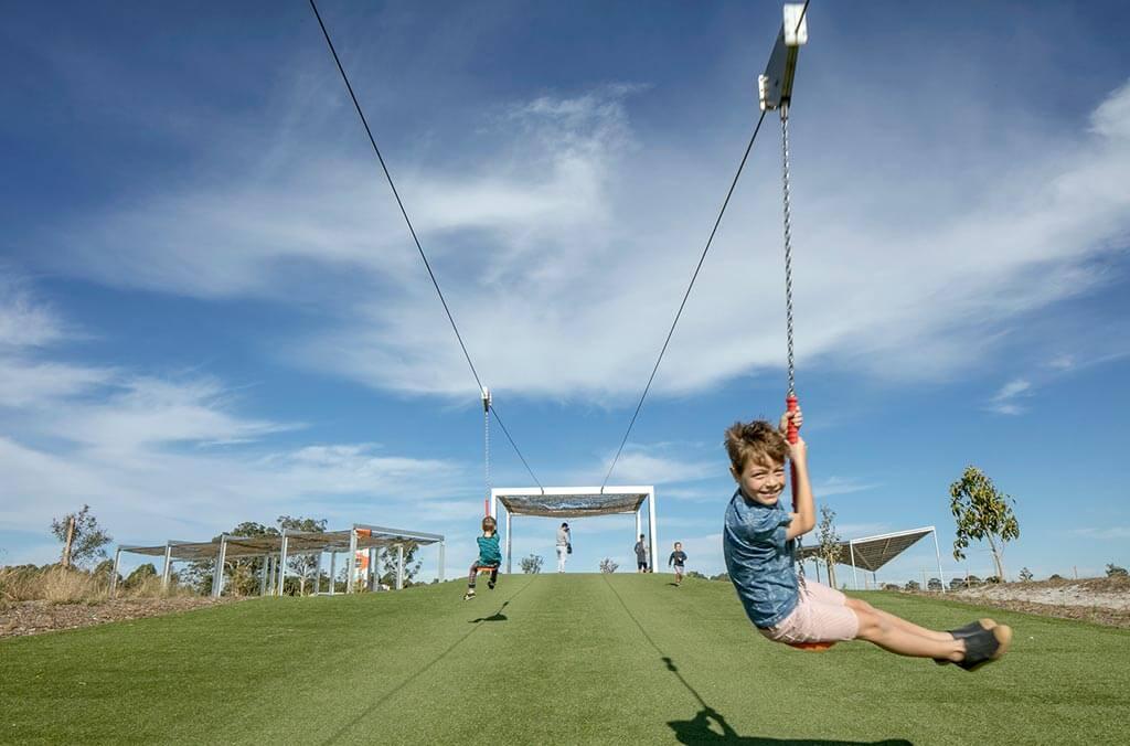 A young boy swings on a rope at Bungarribee playground.
